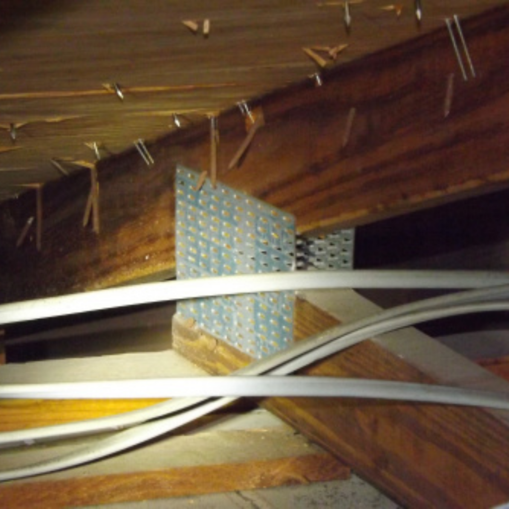 Home inspector identifying roof-to-wall connection during wind mitigation in port st. lucie, fl